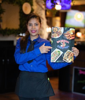 Mariscos Nayarit team member presenting the menu
